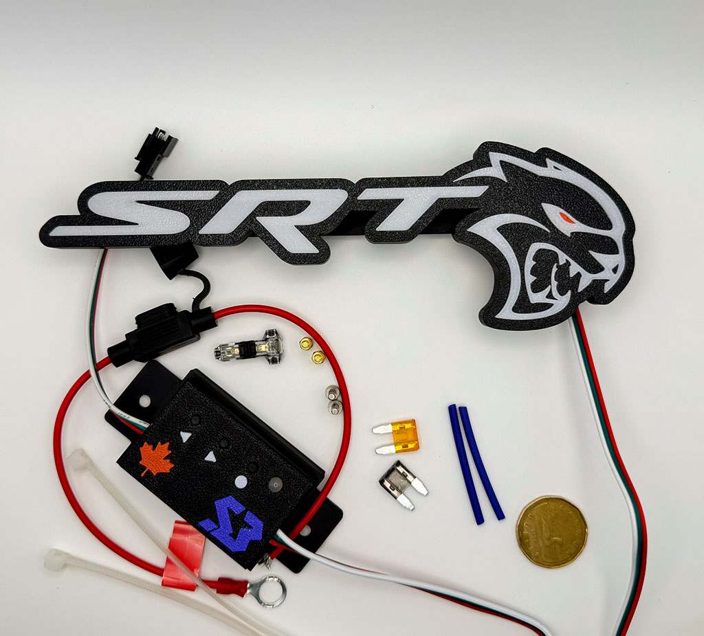 SparkBadge Hellcat kit laid out: badge, controller, and harness